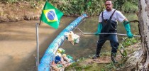 Vendedor gastou cerca de mil reais com a construção da barreira; ele mantém o rio limpo tirando o lixo acumulado na ferramenta que construiu