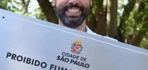 O alcaide tucano Bruno Covas com placa proibindo fumar nas praças e parques de São Paulo