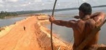 Índio mira a barragem de Belo Monte
