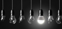 Idea concept with broken bulbs and one glowing LED bulb