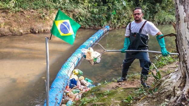 Vendedor gastou cerca de mil reais com a construção da barreira; ele mantém o rio limpo tirando o lixo acumulado na ferramenta que construiu