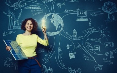 Female teacher holding solar panel and flashing light bulb --- Image by © Ben Hupfer/Corbis