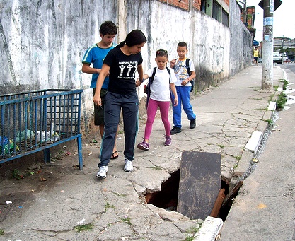 Pedestres tem que driblar buracos, lixeiras, etc, nas calçadas.