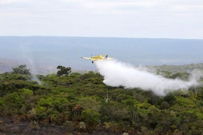 Avião sobrevoa a área jogando água