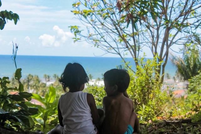 Crianças indígenas, diante da floresta e do mar em aldeia Pataxó na Bahia: integração com a natureza. Foto de Alice Pataxó