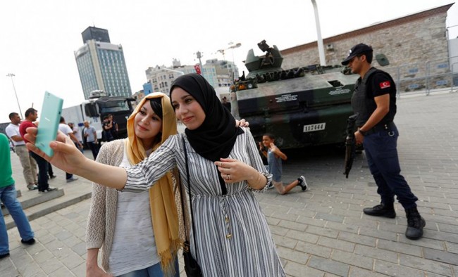 Turistas argelinas fazem uma selfie em frente a um tanque abandonado - golpe para turista ver...